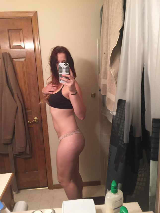 Девушка стоит перед зеркалом, наслаждаясь своей фигурой и делая селфи – фото 5