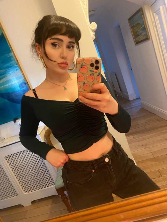 Фото Юная девушка с темными волосами показала свою грудь в колготках и без них