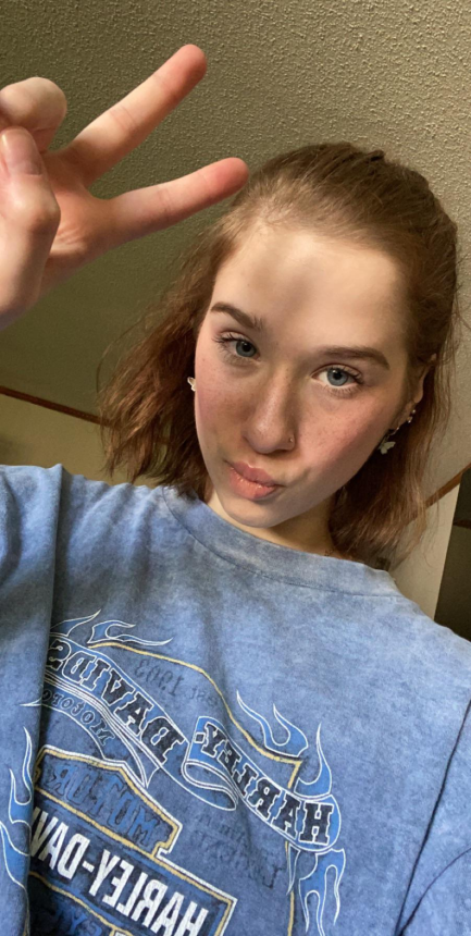 Фото Худенькая девушка делает фото своей пушистой кошечки, показывая ее всем.